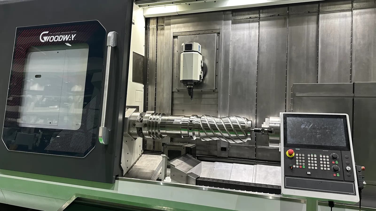 CNC turning center machining a large worm shaft from solid bar stock